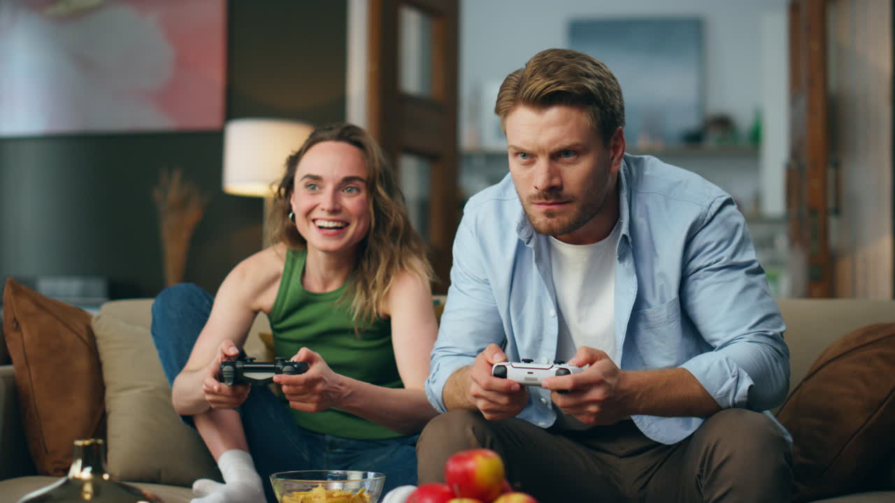 Amici attivi che giocano a un videogioco in una casa accogliente. Coppia entusiasta che cerca di vincere.