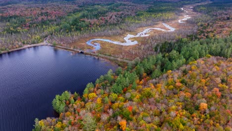 Vista-Aérea-De-Un-Río-En-El-Norte-Del-Estado-De-Nueva-York-Rodeado-De-Follaje-De-Otoño-Y-Un-Lago.