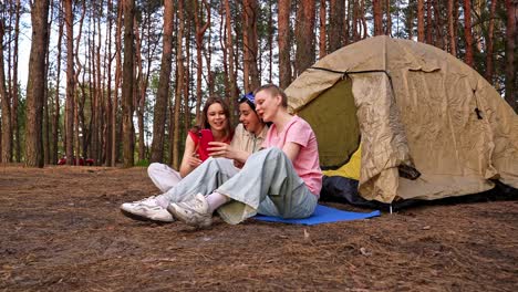 three friends enjoying camping in a forest