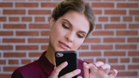 Face,-phone-and-business-woman-by-brick-wall