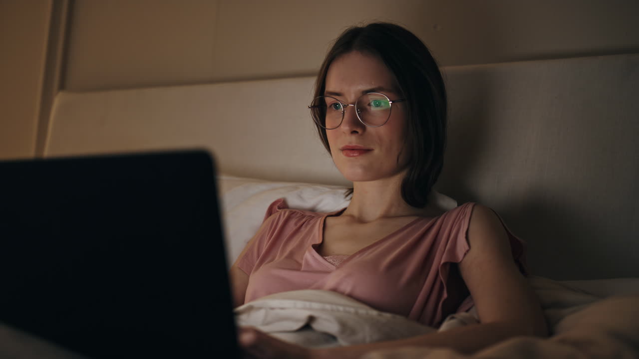 Closeup woman working laptop at night screen light. Relaxed girl typing message