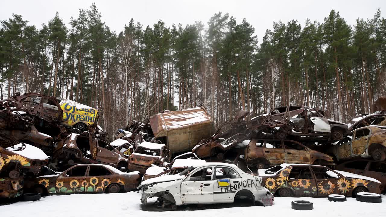 A pile of destroyed and burnt cars, stacked on top of each other, is seen in Irpin, Ukraine, during winter, after battles between Ukrainian and Russian forces in the ongoing war.