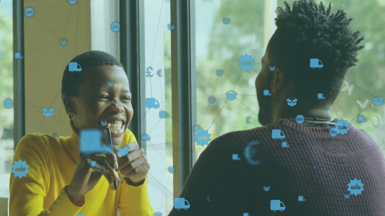 Animation of network of connections with icons over african american couple talking in cafe