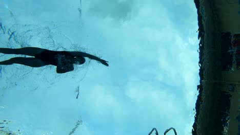 Underwater-Shot-of-a-female-swimming-through-the-lanes-of-a-pool