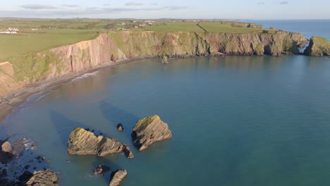 Drone-Hora-Dorada-Bahía-Escondida-Con-Pilas-De-Mar-En-La-Costa-De-Cobre-Waterford-Irlanda