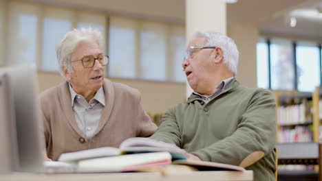 hombres mayores con gafas hablando mientras tienen una lección en la biblioteca