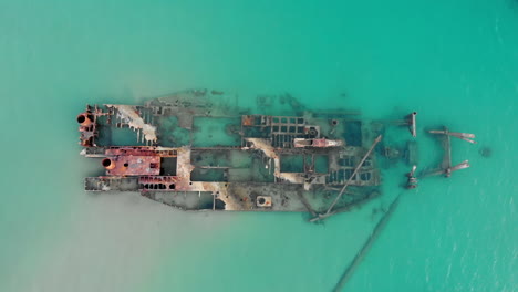 Drone-Video-ascending-slowly-overhead-shipwreck-Blue-sea-waters-top-down-view