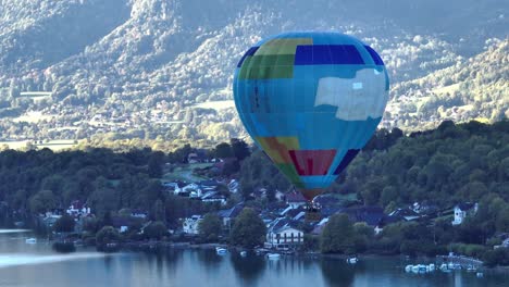 hot air balloon descending down by a lake in a summer morning in annecy, france