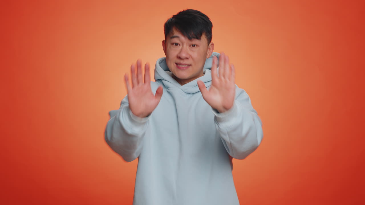 Asian man say no hold palm folded crossed hands in stop gesture warning of finish prohibited access
