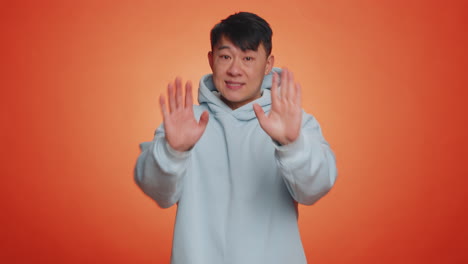 asian man say no hold palm folded crossed hands in stop gesture warning of finish prohibited access