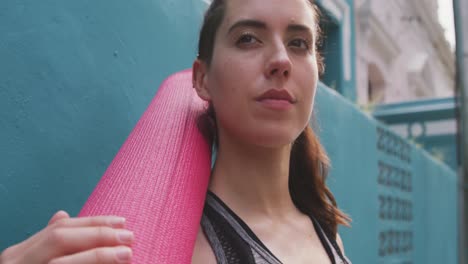 caucasian woman with a yoga mat