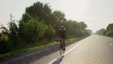 Male-cyclist-in-helmet-rides-bicycle-along-an-empty-track
