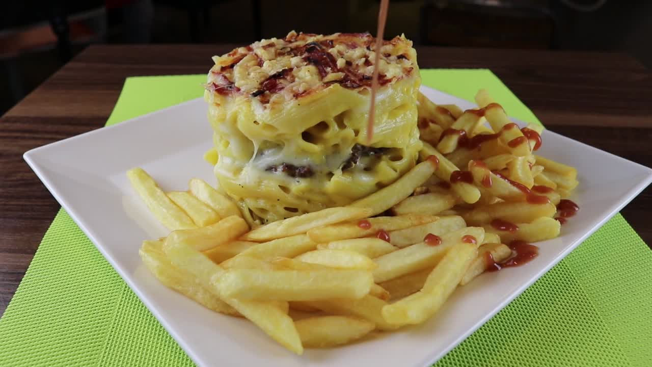 Ketchup Drizzling on French Fries Next to Macaroni and Cheese