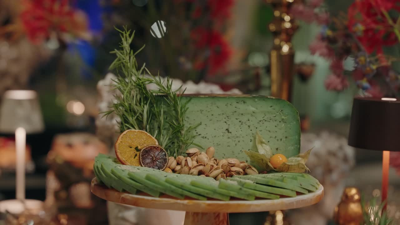 green cheese with dried fruits herbs and nuts on decorative party table setting