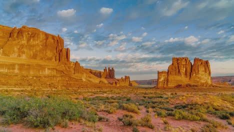 la vista panorámica y cinematográfica del atardecer y el amanecer en el famoso parque nacional arches y sus vibrantes puntos de referencia de red rock en utah, arizona, estados unidos con cielo, nubes y sol en el paisaje desértico.