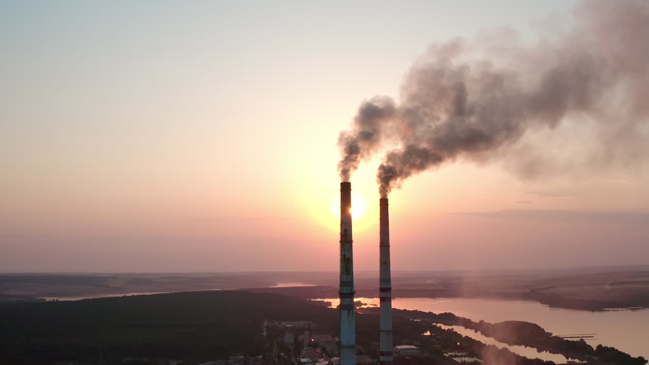 Big factory tubes smoking on sunset. Huge industrial ecology smog building.