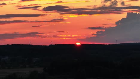 Fascinante-Puesta-De-Sol-Cuando-El-Sol-Se-Esconde-Bajo-El-Horizonte,-Proyectando-Un-Tono-Rojo-Vibrante