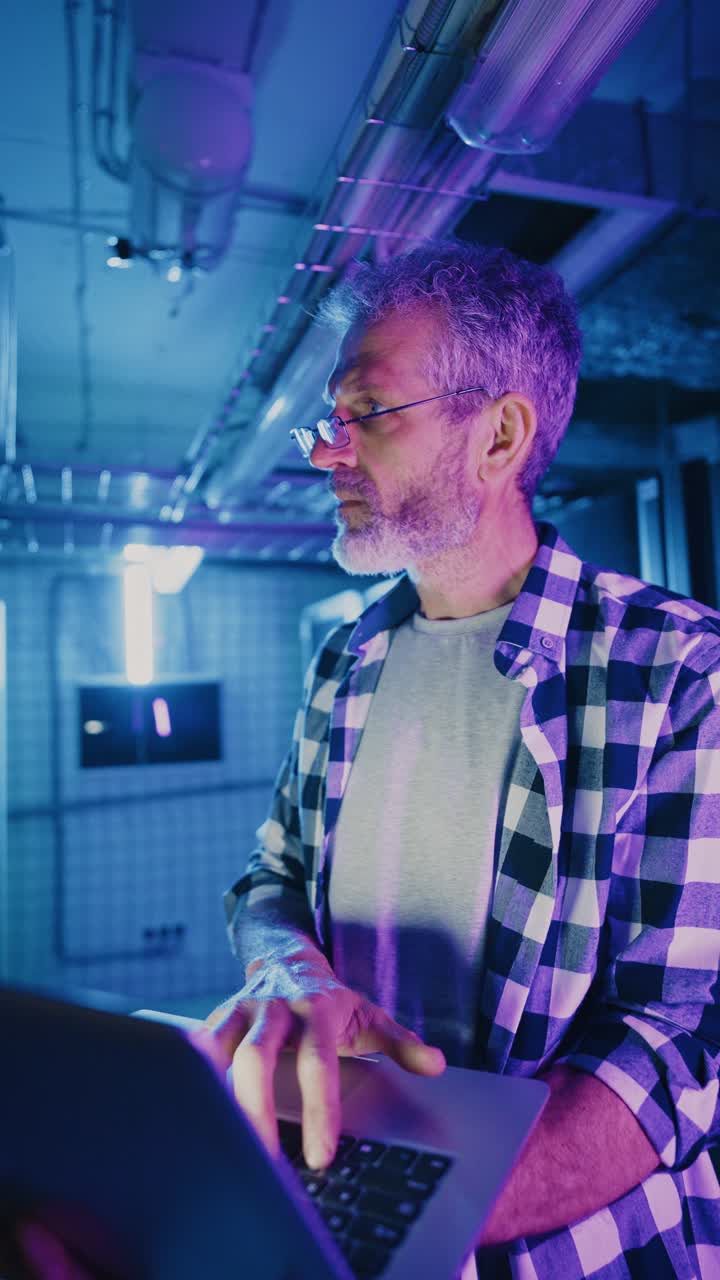 Technician Working in a Server Room at Night