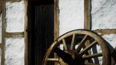 old wood wheel and black door at white house