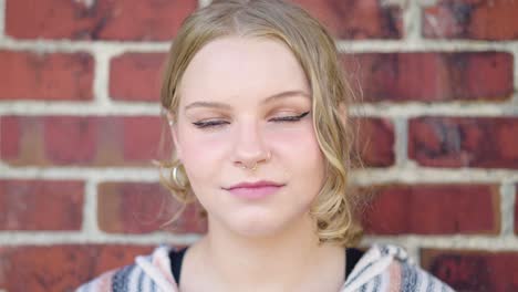 close up of a girl's eyes and face outside agianst a brick wall