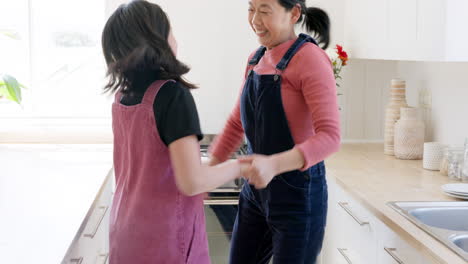 music, dance and mother with girl in a kitchen