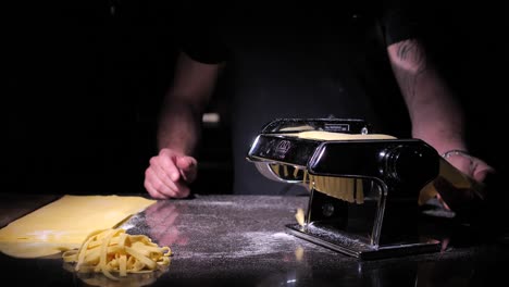 unrecognizable chef cutting dough making fresh homemade pasta, close up