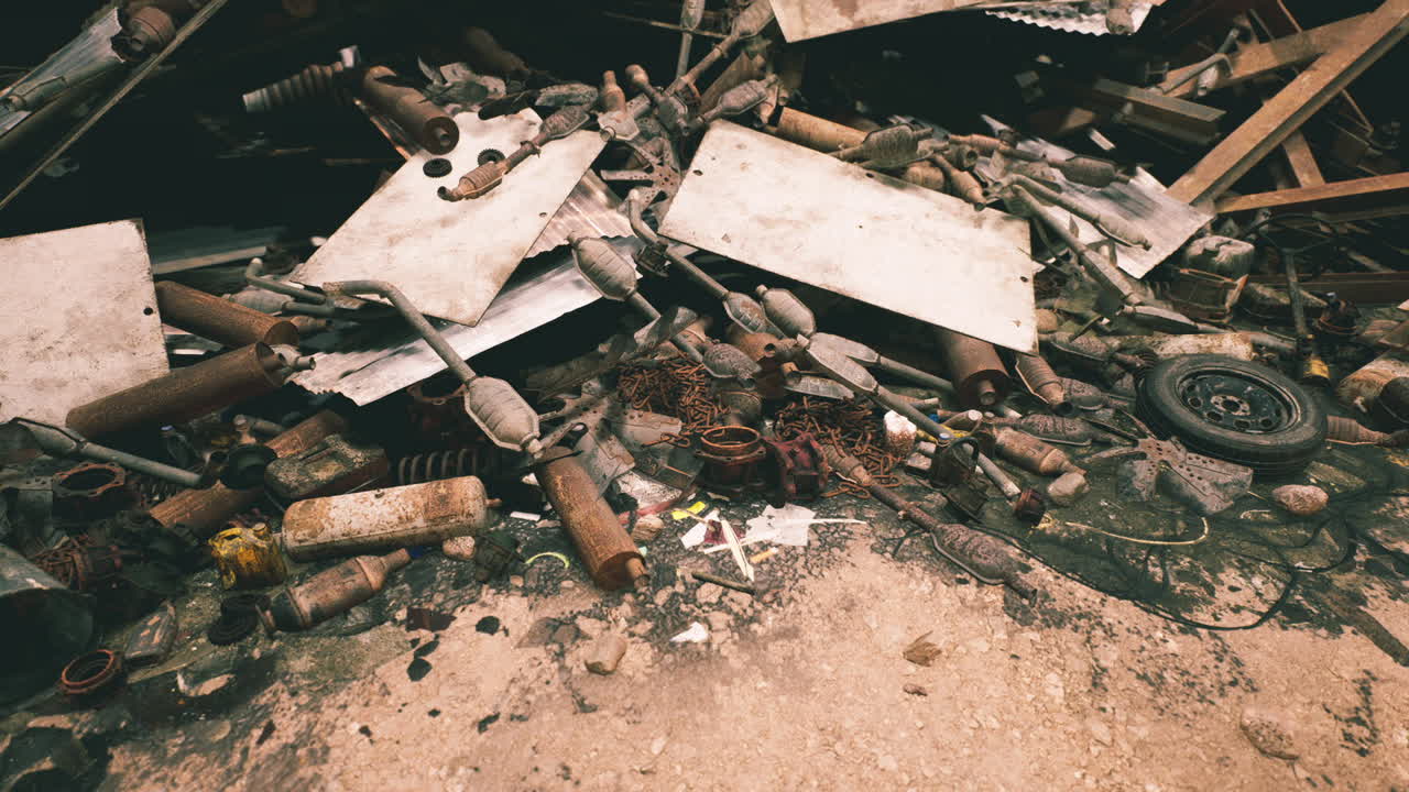 Discarded debris and scrap materials litter an industrial site during daylight
