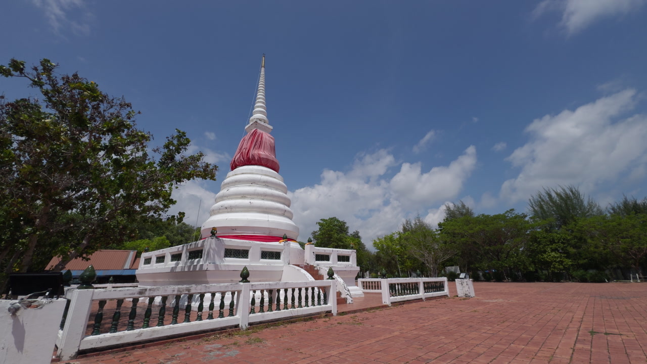 Side view of Phra Chedi Klang Nam pagoda in Rayong Thailand. Buddhist temple and cultural landmark under blue sky, static shot in Southeast Asia.