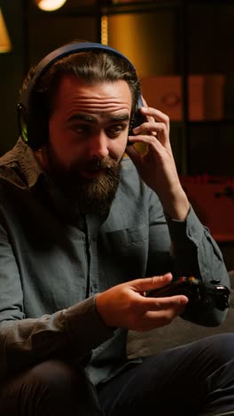 vertical video smiling man putting headphones on to play videogames with teammates