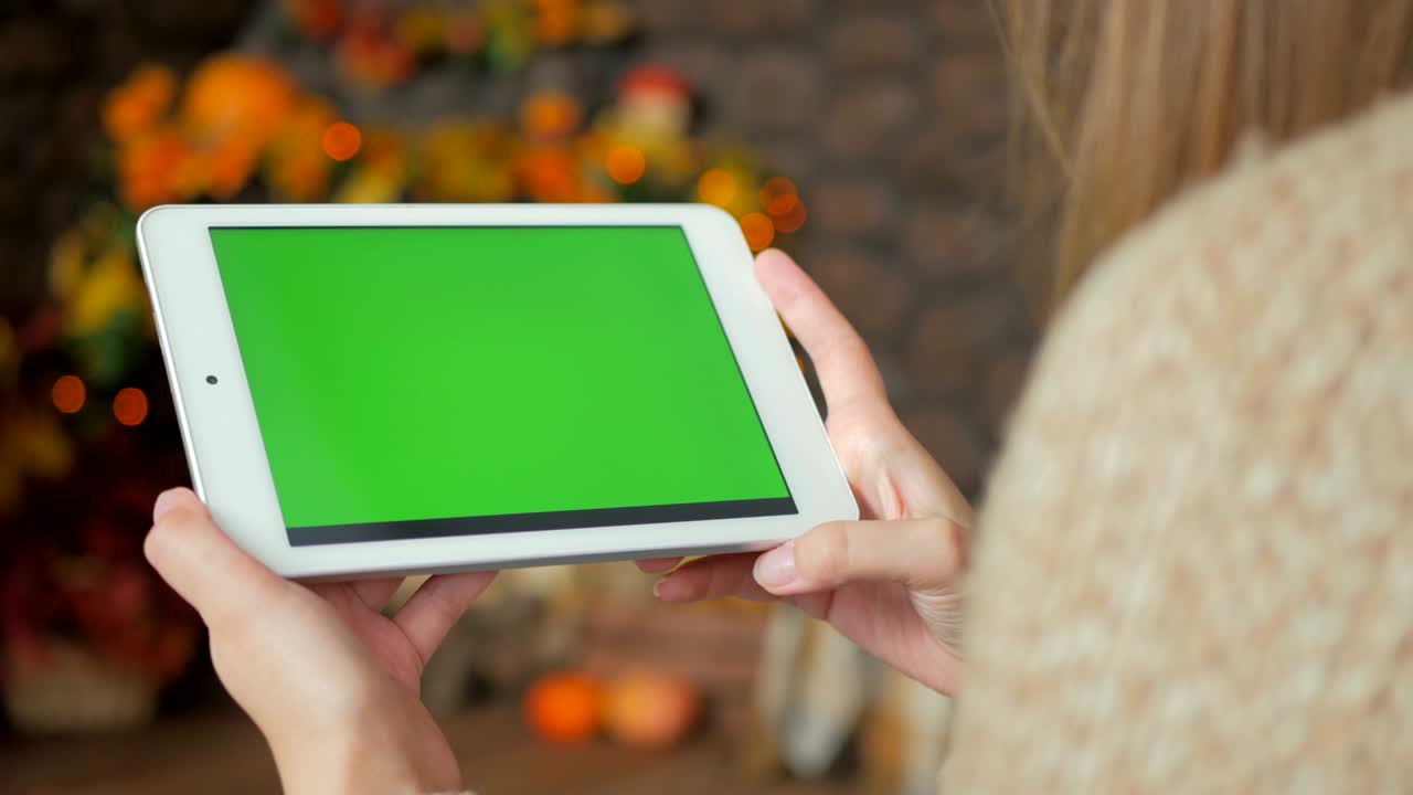 mujer mirando una tableta con pantalla verde