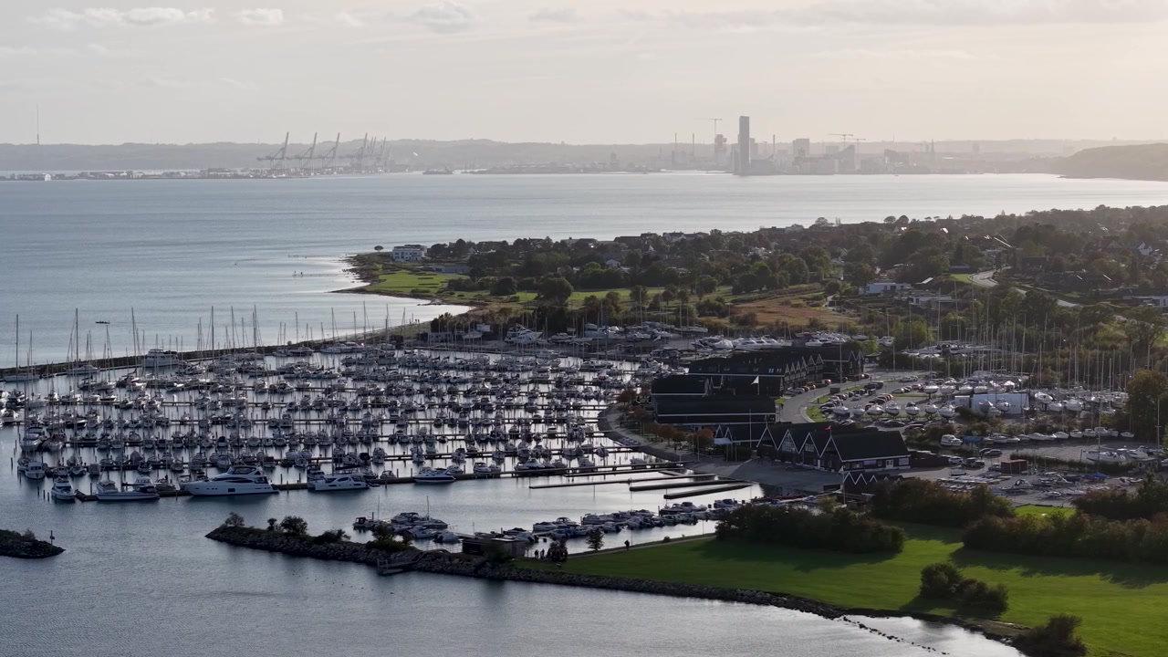 Harbor with boats under a city skyline at sunrise.