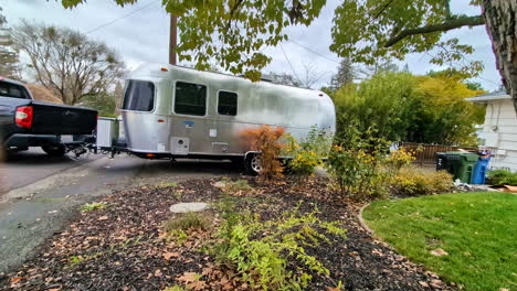 silver airstream travel trailer parked on residential street