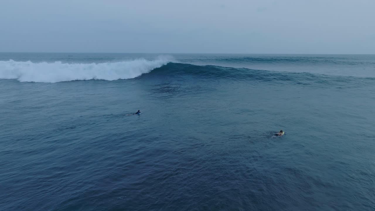 Vista aerea al rallentatore di surfisti al tramonto a La Bocana El Tunco, El Salvador