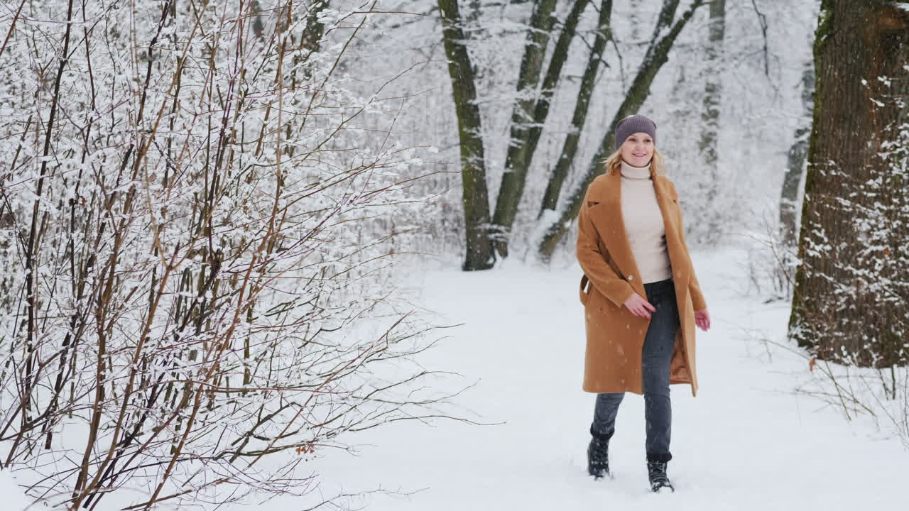 mujer elegante disfruta de un paseo por el bosque nevado