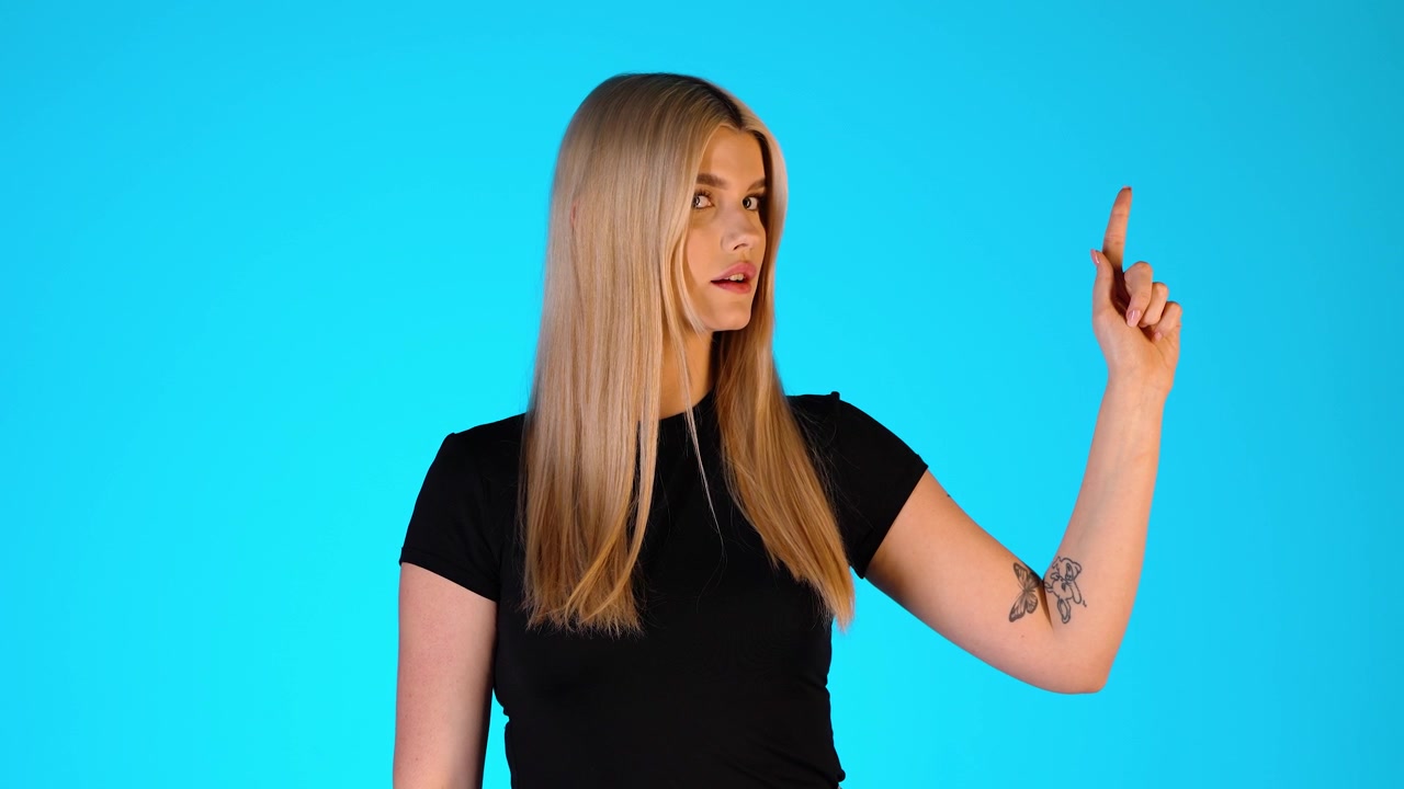 Pretty Blonde Woman Pointing Up With Index Finger, Presentation Gesture, Studio Portrait