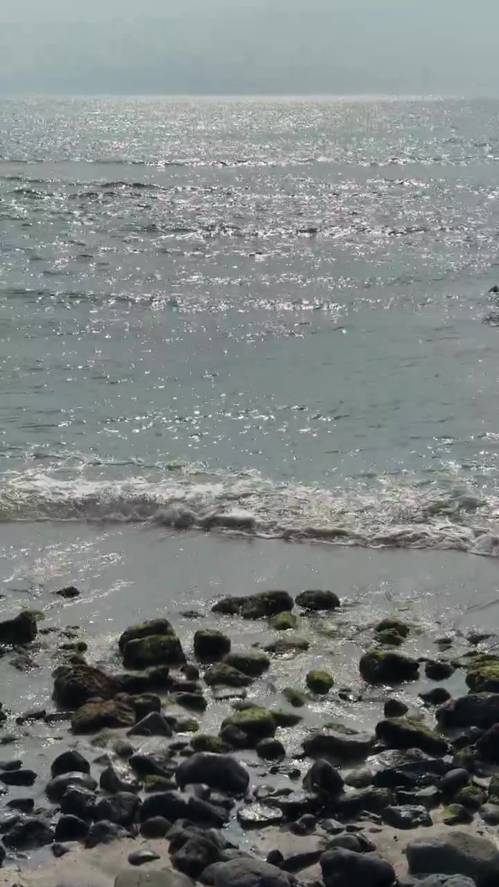 Onde delicate che si infrangono su una costa rocciosa.