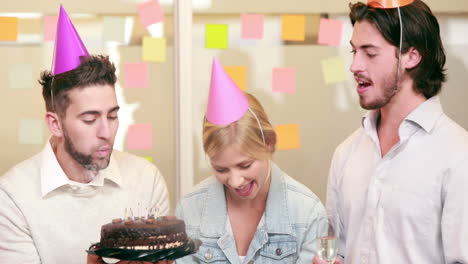 un equipo de negocios casual sonriente celebrando su cumpleaños.