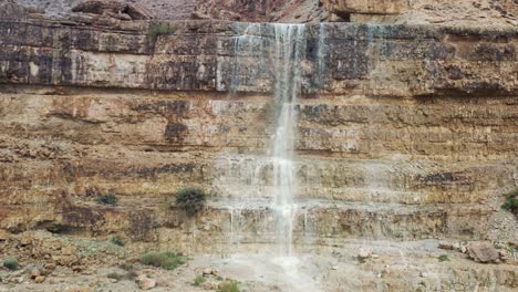 Israel,-desert-waterfall-after-rain,-flood-water,-drone-fly-down-shot