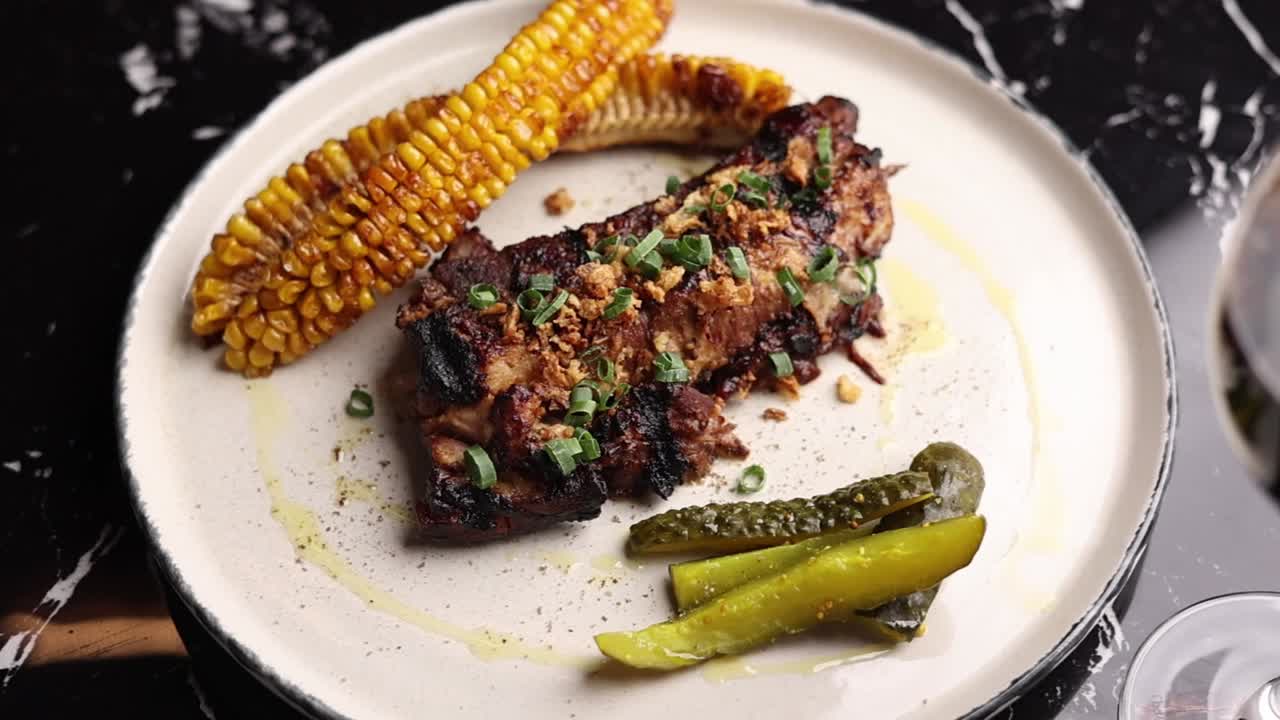 costillas de cerdo a la parrilla con maíz y pepinillos