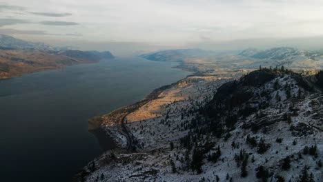 toma aérea panorámica del lago kamloops durante el invierno, un paisaje desértico montañoso parcialmente cubierto de nieve bellamente iluminado durante la hora dorada con grandes sombras