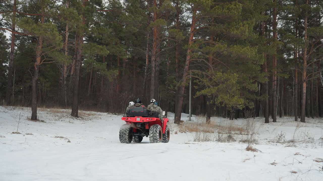 L'emozione di una corsa nella foresta invernale. Terreno innevato impegnativo con il pilota che sfreccia tra i pini. Energico viaggio invernale con un ATV che spruzza neve mentre naviga in un denso paesaggio di pini.