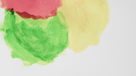 video of red, yellow and green paints with copy space on grey background