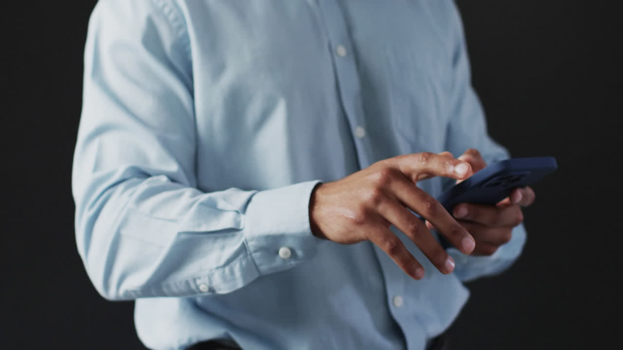 Video of biracial businessman holding smartphone and using holographic display, copy space