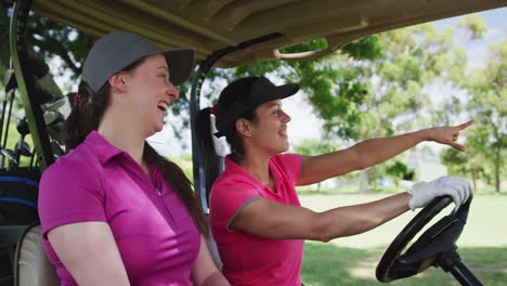 Zwei-Kaukasische-Frauen,-Die-Golf-Spielen-Und-Auf-Einem-Golfwagen-Fahren,-Reden-Und-Lachen