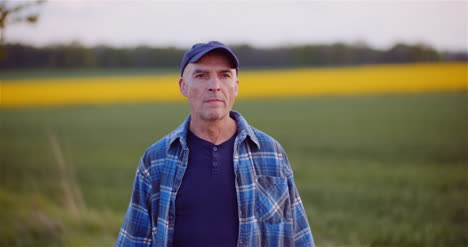 positive adult farmer smiling into camera at field agriculture 1
