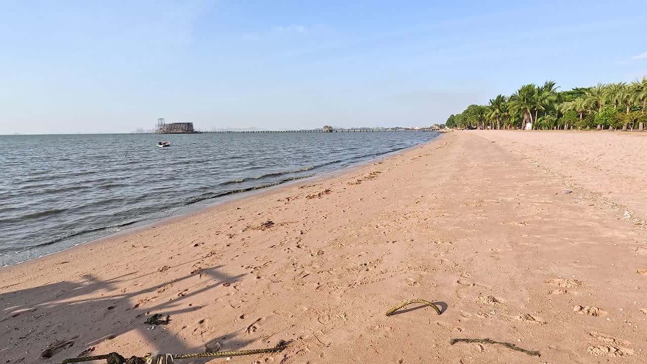 спокойный пляж с мягкими волнами и чистым небом.
