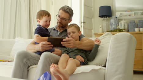 Father-and-kids-using-digital-tablet-on-sofa-4k