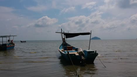 drone flying at low altitude from right to left along coastline with fishing boats on penang island in malaysia