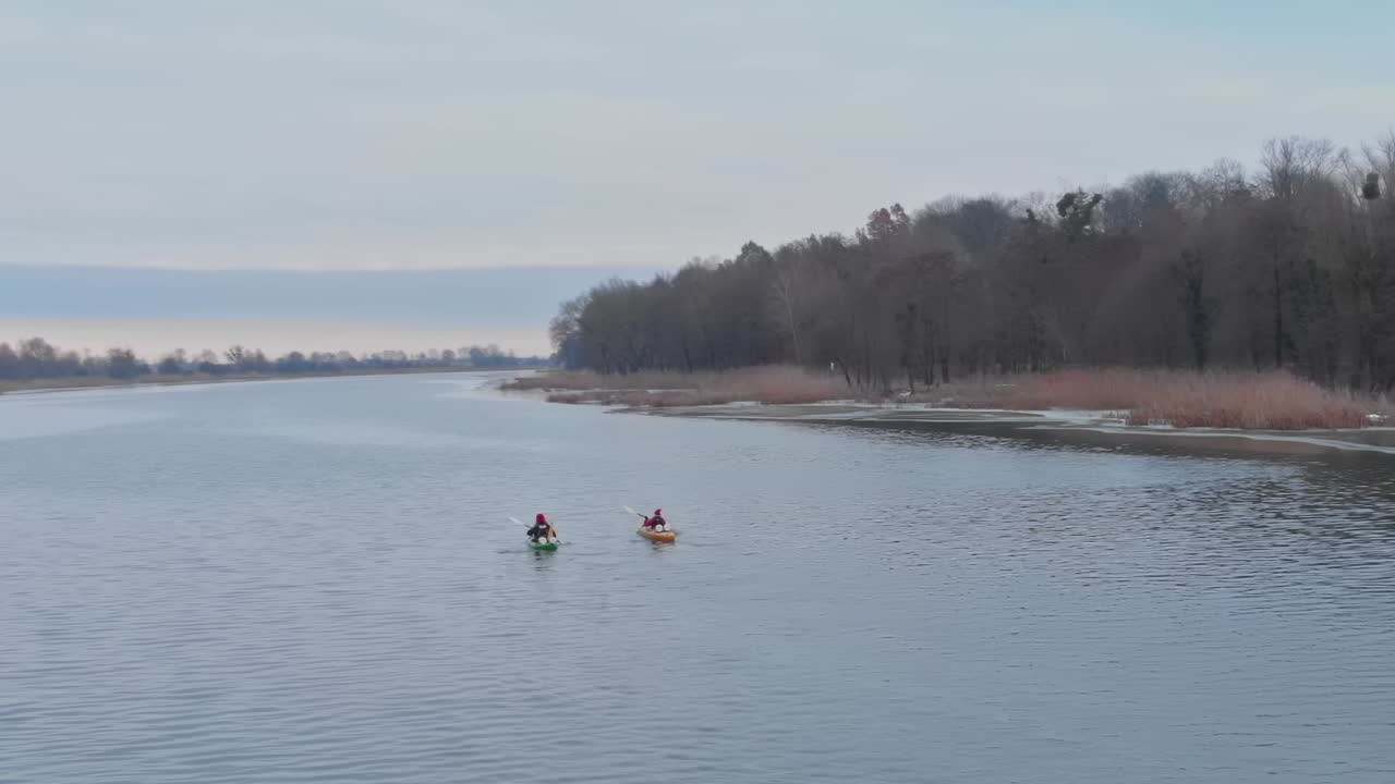 Kajakroere padler på floden nær Malbork i Polen i skumringen.