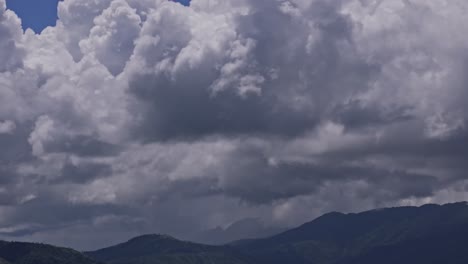 thick dark grey storm clouds over a dark mountains landscape